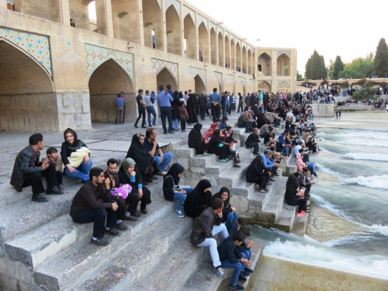 peopla at Khaju bridge enjoying the waters of the Zayandeh river in Isfahan Iran