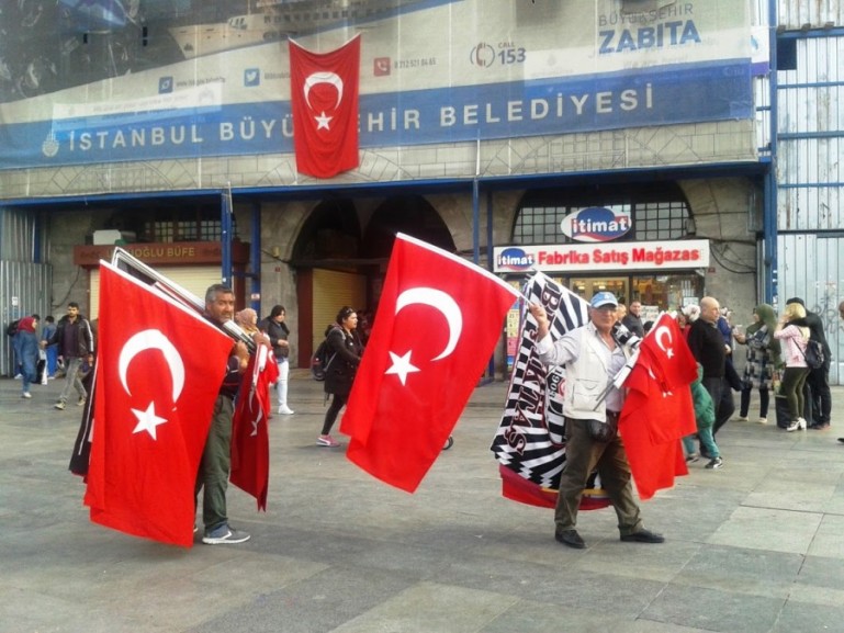 Istanbul itinerary: men selling Turkish flags near the Istanbul bazaar in Istanbul Turkey